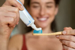 A patient maintaining their teeth whitening results by brushing their teeth.
