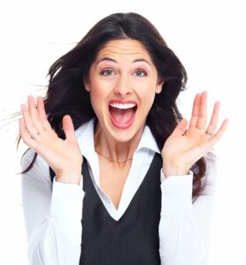 A woman displays a surprised expression, her eyes wide and mouth slightly open, conveying astonishment or disbelief.