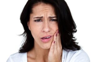Woman holding her face with a pained expression.